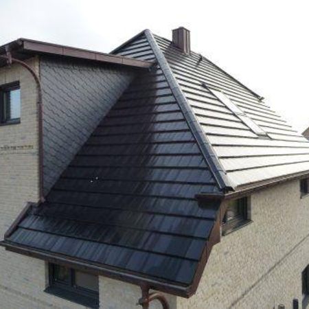 Schwarzes Steildach auf einem hellgrauen Haus - Dachdeckerei Bender